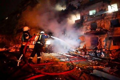 Firefighters hose down burning debris following a rocket attack on Kiev. AP