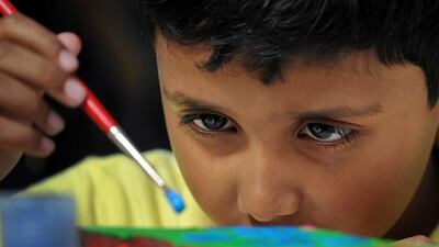 Elvin Mathew, 6, focuses on his painting project during the ‘Picture This’ art workshop for children with autism at Umm Al Emarat Park in Abu Dhabi. Delores Johnson / The National