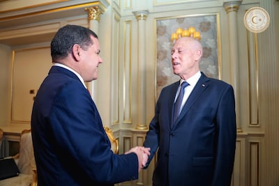Tunisia's President Kais Saied shakes hands with Libya's interim Prime Minister Abdul Hamid Dbeibeh in Tripoli. Reuters