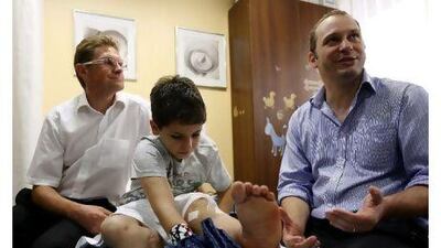 Oday Al Jamal, 12, a Palestinian boy brought over to the UAE for free surgery, with Wendelin Lauxen, left, and Dr Marc Sinclair at the Medcare Hospital in Dubai.