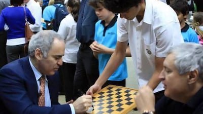 Daniel Kovacevic, a grade 12 pupil at the British International School Abu Dhabi, gets the former world champion and grandmaster Garry Kasparov to autograph his chess board during the launch of the UAE´s branch of the Kasparov Chess Foundation in Abu Dhabi yesterday. Ravindranath K / The National