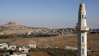 The minaret of a mosque stands on the foreground as the Israeli settlement of Tekoa near the Palestinian West Bank town of Bethlehem. AFP