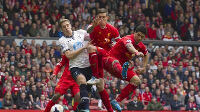 Liverpool's Luis Suarez, right, and Daniel Agger, centre, and Tottenham's Michael Dawson, centre left, lunge for the ball as Jordan Henderson, out of frame, scores from a free kick during Liverpool's 4-0 win on Sunday. Jon Super / AP / March 30, 2014