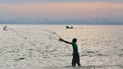 A fisherman casts his net as pre-monsoon clouds gather over the Arabian Sea in Kochi, India. Sivaram V / Reuters