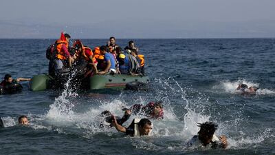 Migrants whose boat stalled at sea while crossing from Turkey to Greece swim to shore near Lesbos, Greece. A boat with 46 migrants sank Sunday in Greece and the coast guard says it is searching for 26 missing off the eastern Aegean island of Lesbos. Petros Giannakouris / AP