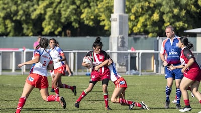 An Al Maha School girls player is tackled.