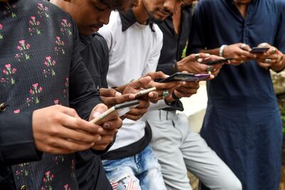 In this photo taken on Sunday, November 10, 2019, youngsters watch videos on video-sharing app TikTok on their mobile phones in Mumbai, India. AFP