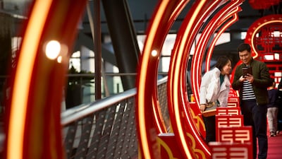 Visitors check their smartphones at a Lunar New Year display at an upscale shopping mall in Beijing. Mark Schiefelbein / AP Photo