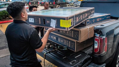 Four televisions being loaded onto a customer's vehicle during the Black Friday sales in Los Angeles on November 29, 2019. Mark Ralston / AFP