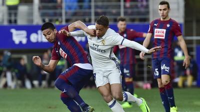 Real Madrid’s Mariano Diez Mejia, centre, duels for the ball with Eibar’s Mauro dos Santos. Alvaro Barrientos / AP Photo