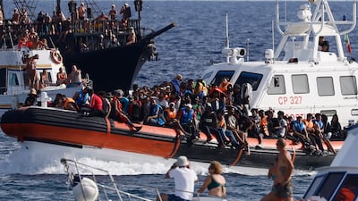 An Italian coastguard boat carries a group of migrants near the port of the Sicilian island of Lampedusa. La Presse / AP