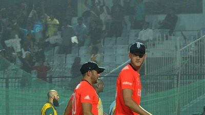 England cricket captain Stuart Broad, right, and South Africa batsma Hashim Amla left walk back to the pavillion with others as play stopped after one of floodlight tower malfuntioned during the ICC World Twenty20 tournament cricket match between England and South Africaat The Zahur Ahmed Chowdhury Stadium in Chittagong on March 29, 2014. AFP PHOTO/Prakash SINGH