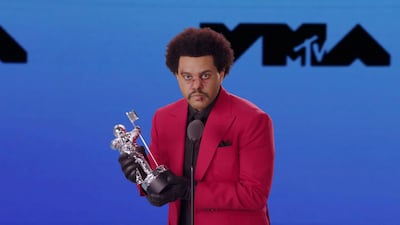 The Weeknd, weaing make-up that makes him look bruised and cut, accepts the award for Best R&B artist during the 2020 MTV VMAs. Reuters