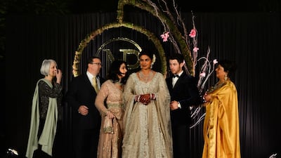 The newlyweds with their families - Chopra's mother is pictured right