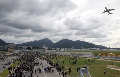 A plane flies overhead as protesters block a road leading to the Hong Kong International Airport in Hong Kong. EPA