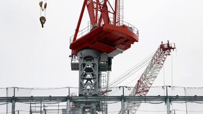 Workers construct a building in Tokyo. Japan has revised upward its estimate of growth in the first quarter of this year, thanks to smaller drop in business investment than reported earlier. Eugene Hoshiko/AP