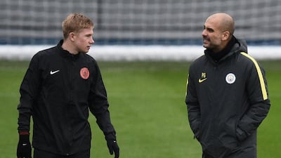 Manchester City manager Pep Guardiola, right, speaks with midfielder Kevin De Bruyne during a training session at the City Football Academy in Manchester, northern England, on November 22, 2016. Oli Scarff / AFP