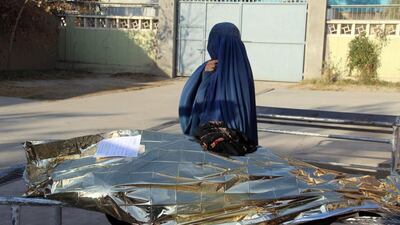 An Afghan woman stands beside the body of her relative, one of the five female staff of Kandahar Airport, , Afghanistan, killed by gunmen on December 17, 2016. Muhammad Sadiq / EPA