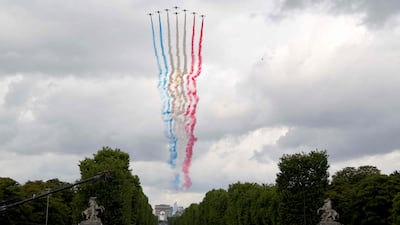 The Air Force Elite acrobatic flying team releases trails in France's national colours as it flies over the parade. AFP