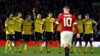 Middlesbrough players stand together as Wayne Rooney walks back after missing his penalty in Manchester United's shoot-out loss in the League Cup on Wednesday. Nigel Roddis / AFP / October 28, 2015