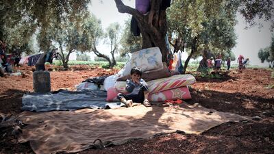 Esara'a son, Ahmad nine years old standing between the trees in Harm's mountain waiting for the tent to be set up, surrounded by blankets and a dove to sleep on.