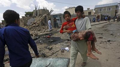 A man carries an injured boy after a bomb attack in Kabul on May 17, 2015 which killed at least three people when a Taliban suicide bomber rammed his car into a European Union vehicle. Omar Sobhani/Reuters