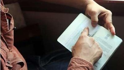 A man shows his fake passport, which he has used to travel to the UAE three times.
