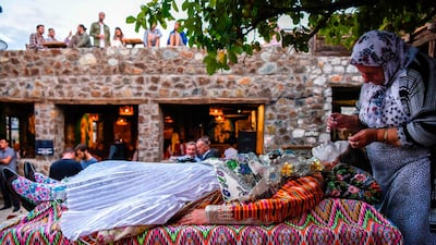 Buqaj lays on her back as she receives a traditional face painting by Sefitagic. AFP