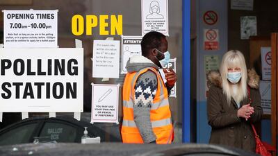 A voter sanitizes her hands as she leaves a polling station during local elections in Oxford. Reuters