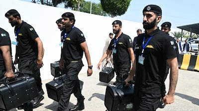 Police commandos from Pakistan’s Federal Board of Revenue carry boxes containing copies of the government's 2026–27 budget outside Parliament House in Islamabad. AFP