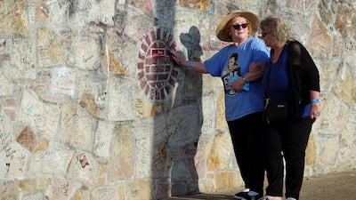 Cheryl Penny assists Ann Lawlor, left, who traveled from England to participate in the candle light vigil where mourners will gather to commemorate the 40th anniversary of the death of singer Elvis Presley at his former home of Graceland, in Memphis. Karen Pulfer Focht / Reuters