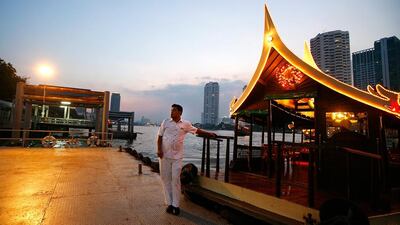 A boatman waits for guests to board a hotel shuttle boat in Bangkok. Paula Bronstein / Getty Images