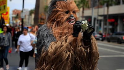Donte, a musician who only gave his first name, straightens out dollar bills on his first day in a brand new Chewbacca costume purchased from eBay for $441, in the Hollywood section of Los Angeles. Donte said he replaced the old one because he wasn't making any money with it. Jae C Hong / AP Photo