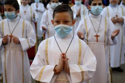 Iraqi Christian children receive their First Communion. All Iraqis have been suffering under the pandemic and security situation in the country. AFP