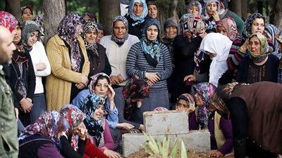 Relatives of Ahmet Uyan, 45, and Ahmet Ceyhan, 23, who were killed in car bombings in the Turkish border town of Reyhanli, mourn at their graves.