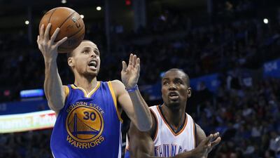 Golden State Warriors guard Stephen Curry, left, goes in for a shot in front of Oklahoma City Thunder forward Serge Ibaka during the second quarter of an NBA basketball game in Oklahoma City, Friday, Jan. 16, 2015. AP Photo/Sue Ogrocki