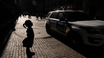 A police car passes a sculpture entitled 'Fearless Girl' outside the New York Stock Exchange (NYSE) in New York in January. AFP