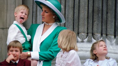 A young Prince Harry sticking his tongue out, much to the surprise of his mother, Princess Diana, on the balcony of Buckingham Palace in 1988