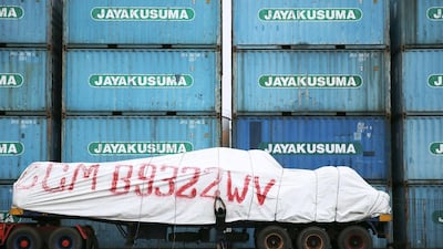 A worker tightens a cover over his truck near containers at Tanjung Priok port in Jakarta, on November 11, 2014. Indonesia's new government is launching a bid to convince sceptical foreign investors to pour billions of dollars into improving the country's dilapidated infrastructure, promising to reduce corruption and bureaucracy. Beawiharta / Reuters