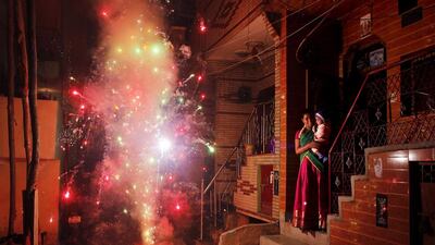 An Indian woman holds her child and watches a firecracker light up in New Delhi on October 23, 2014, the day of Diwali, the annual Hindu festival of lights. Altaf Qadri / AP