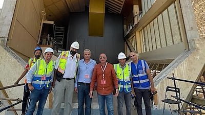Engineers pose for a group photo outside the old museum home of Pharaoh Khufu's solar barque after the vessel has departed for its new home.