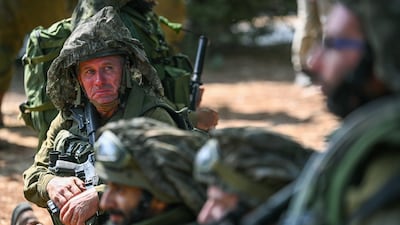 An Israeli reservist sits with fellow troops near the border with the Gaza Strip, where dozens of civilians were killed in a raid by Hamas militants. Getty Images