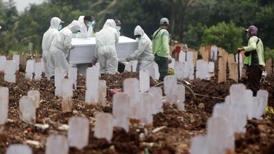 Workers carry the coffin of a person who died of complications from Covid-19 disease during a funeral at Srengseng Sawah Cemetery in Jakarta, Indonesia. EPA