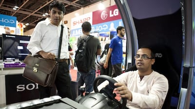 A visitor enjoys the hands-on experience of a virtual racing video game at Gitex Shopper 2013 in Dubai yesterday. Razan Alzayani / The National