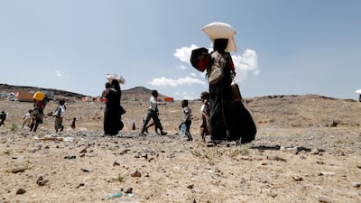 Displaced Yemenis carry donated food as an international donors conference on Yemen begins, March 1 2021. EPA