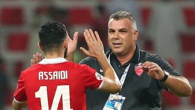Al Ahli coach Cosmin Olaroiu, right, celebrates with Ossama Assaidi at the end of their AFC Champions League semi-final match against Al Hilal on October 20, 2015 in Dubai. Al Ahli won 3-2. AFP PHOTO / MARWAN NAAMANI