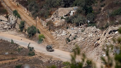 An Israeli military vehicle drives past houses destroyed by Israeli strikes in southern Lebanon. AFP