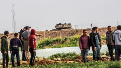 Palestinians demonstrate along along the Gaza-Israel border east of Khan Yunis in the southern Gaza Strip as an Israeli tank is seen across the other side. AFP