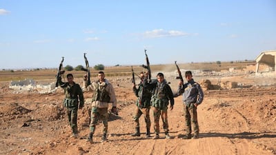 A group of Syrian pro-governement forces raise their guns in celebration on the outskirts of Kweyris near the Kweyris military air base, east of the Syrian province of Aleppo on November 10, 2015 after regime troops broke a more than a year-long siege by ISIL fighters at the major military air base. George Ourfalian/AFP Photo