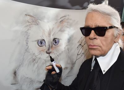 Karl Lagerfeld next to a painting of his cat, Choupette. AFP